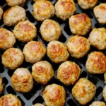 Close-up of golden-brown frozen meatballs cooked in an air fryer basket.