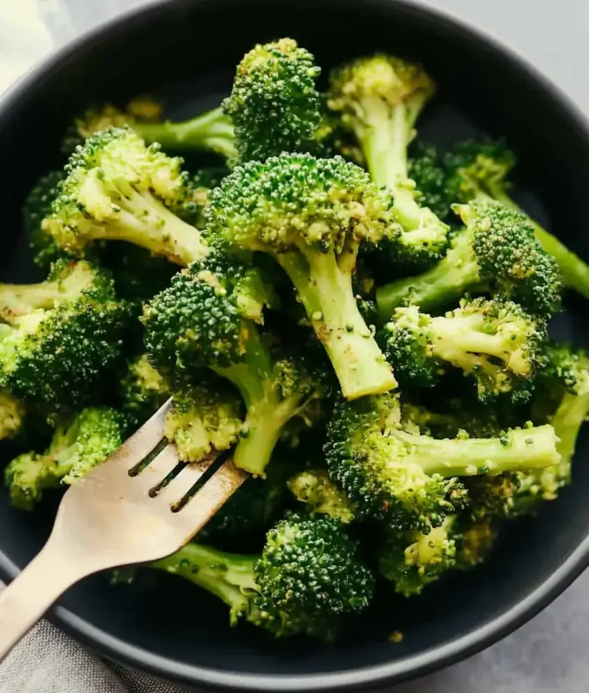 Seasoned broccoli florets served in a dark bowl with a golden fork.
Caption: Tender and flavorful air-fried broccoli, seasoned and ready to enjoy as a healthy side dish.