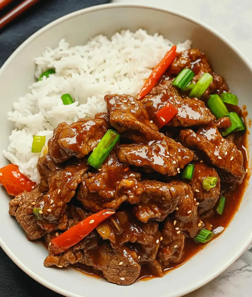 Sweet and savory beef with red bell peppers and green onions over a bed of white rice.