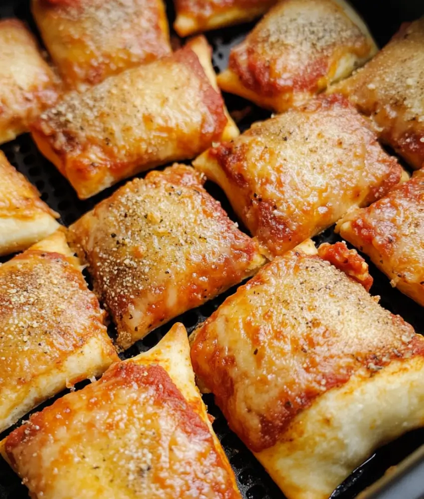 Golden brown pizza rolls with melted cheese and crispy edges, freshly cooked in an air fryer.